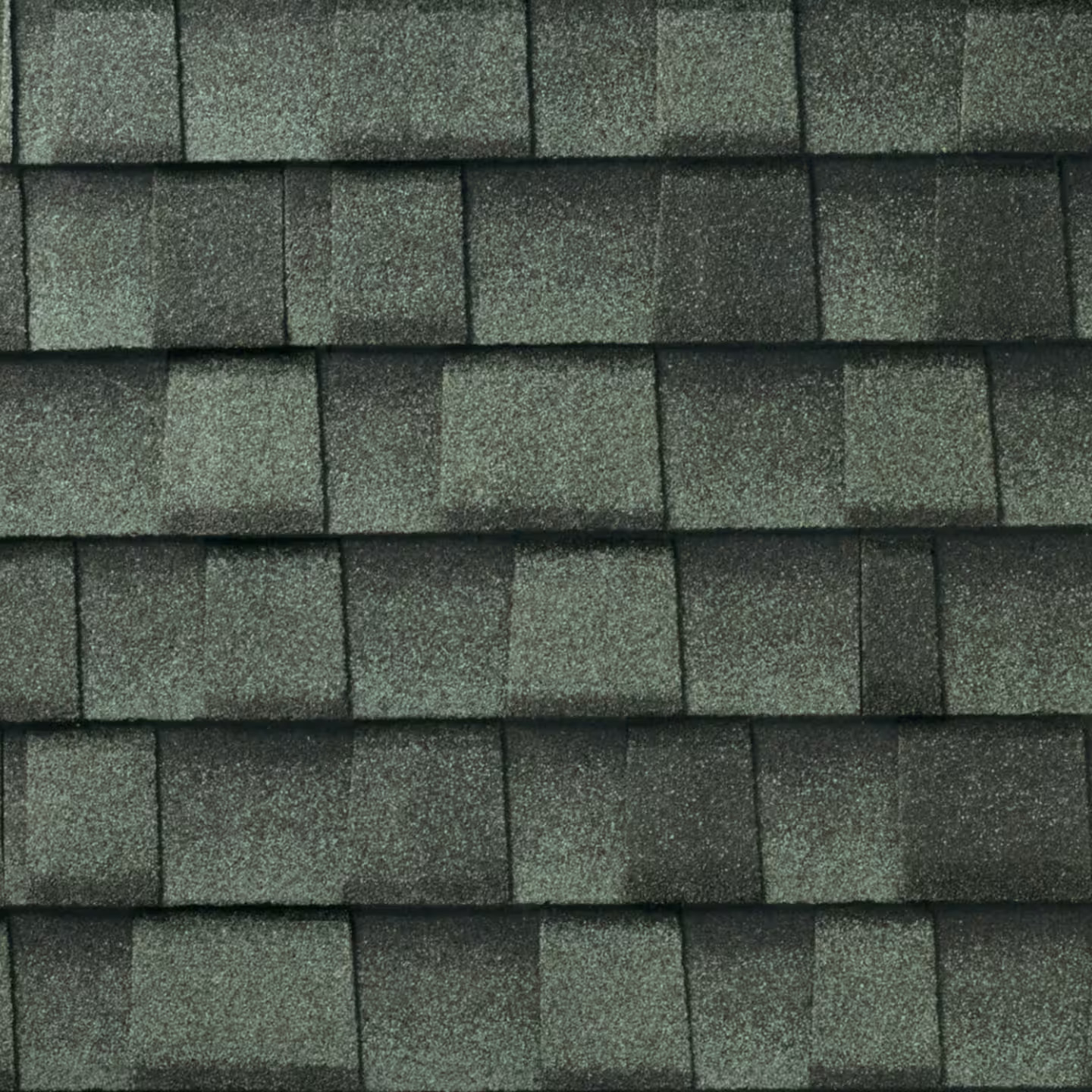 Close-up of green-gray architectural asphalt shingles with blended color variation and texture