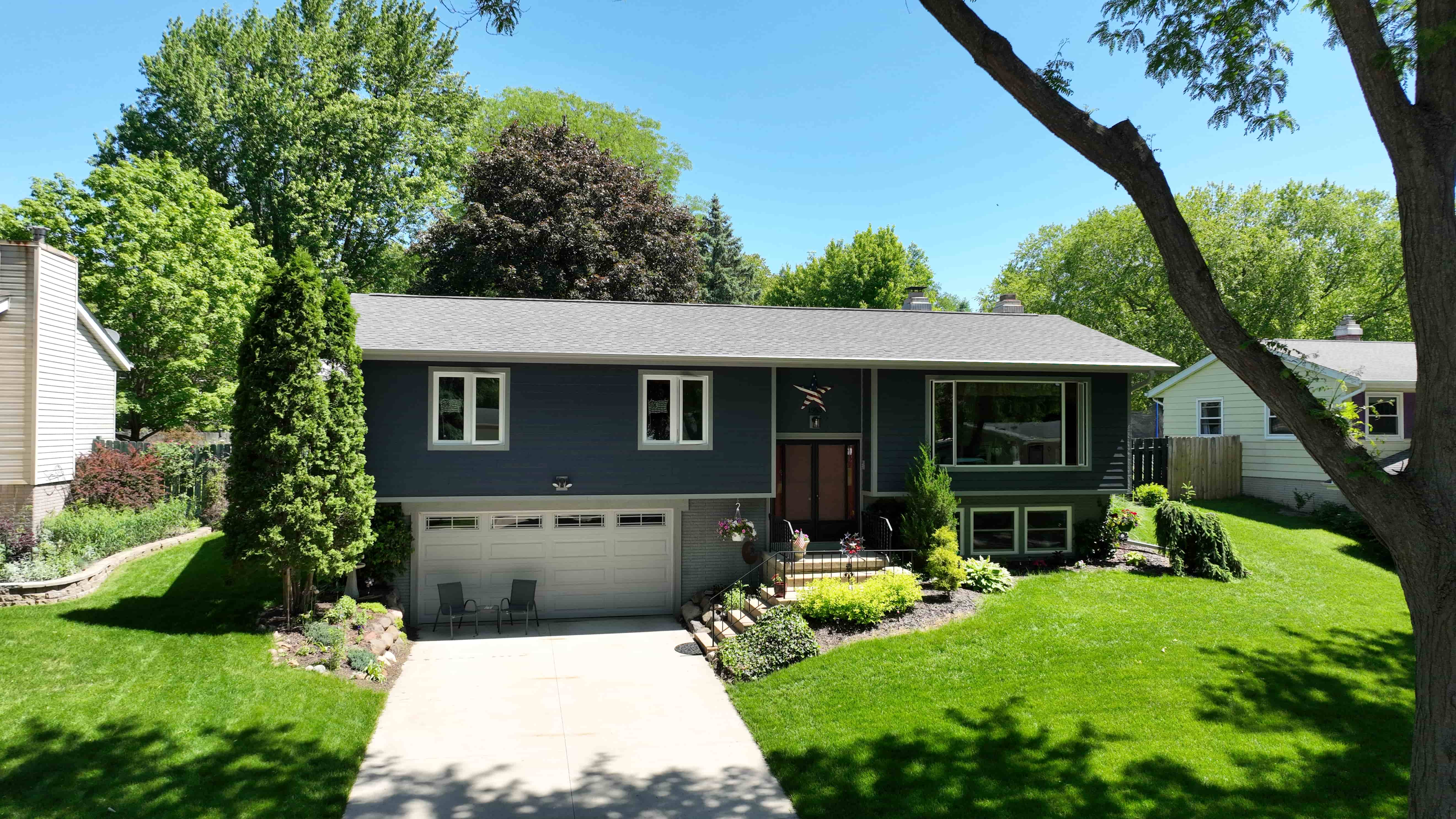 Aerial view of home with new Timberline HDZ shingle roof and full exterior renovation including siding, windows, and gutters