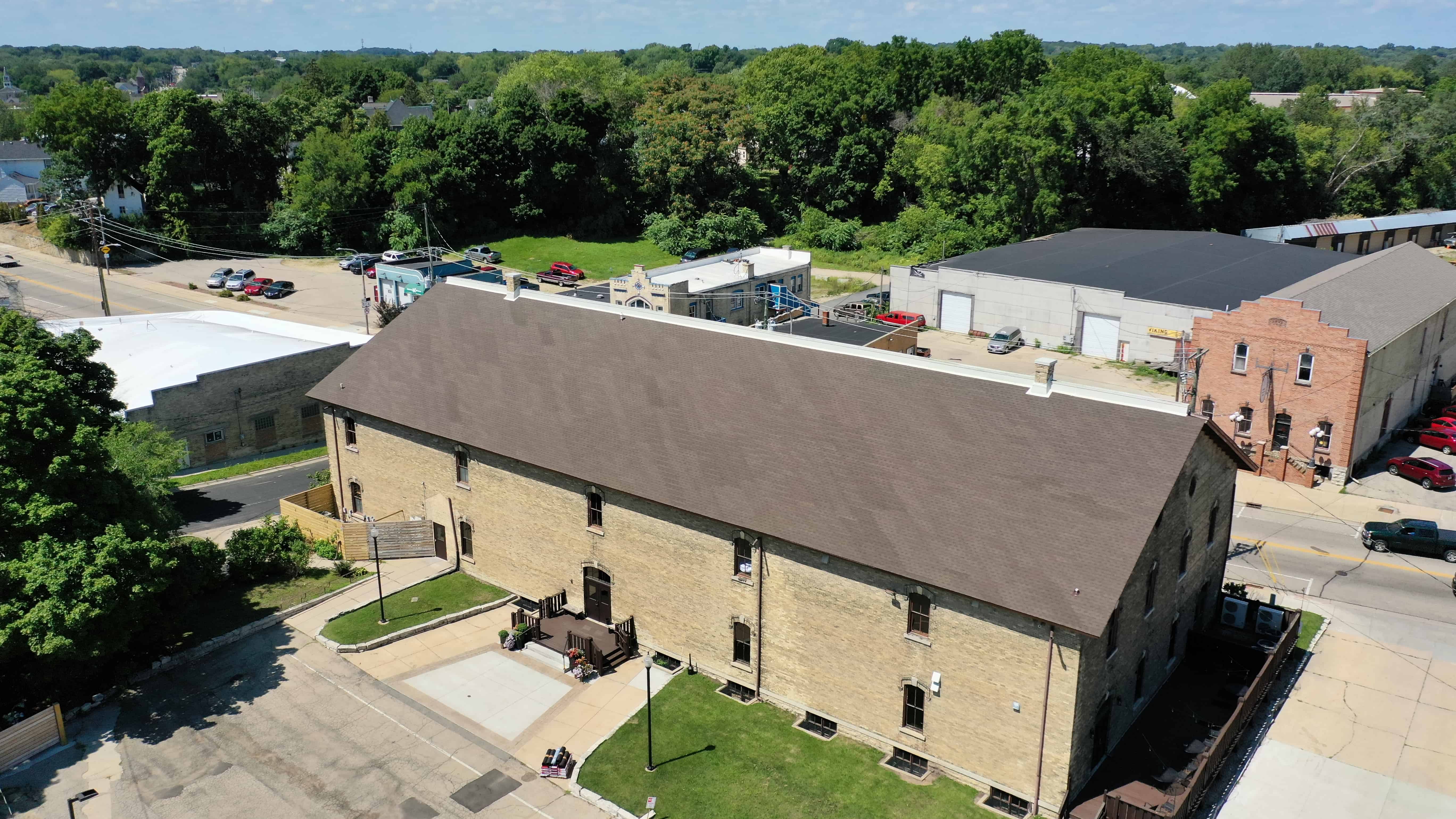 Aerial view of restored wedding venue with new asphalt shingle roof improving durability and overall appearance